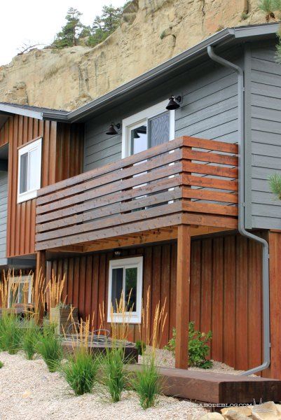 a house with wooden balconies next to a cliff