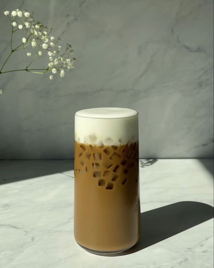 a vase sitting on top of a table next to a white flower pot filled with baby's breath