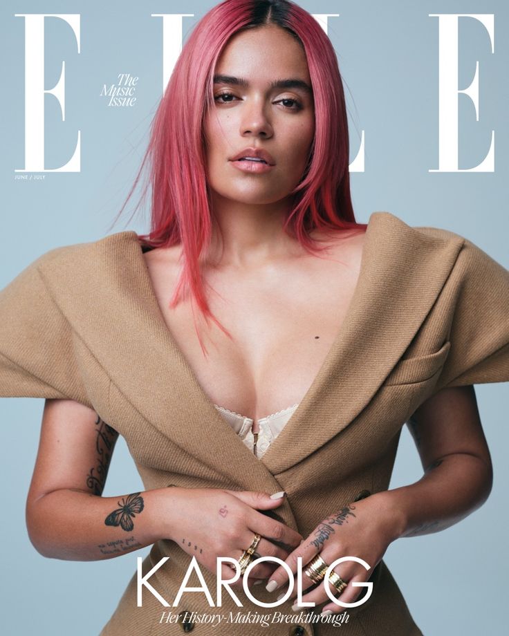 a woman with pink hair and tattoos on the cover of a magazine, wearing a brown jacket