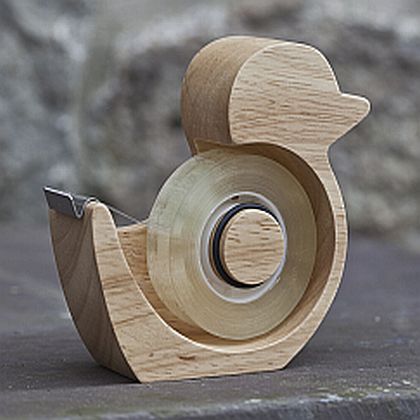 a small wooden object sitting on top of a cement floor next to a stone wall