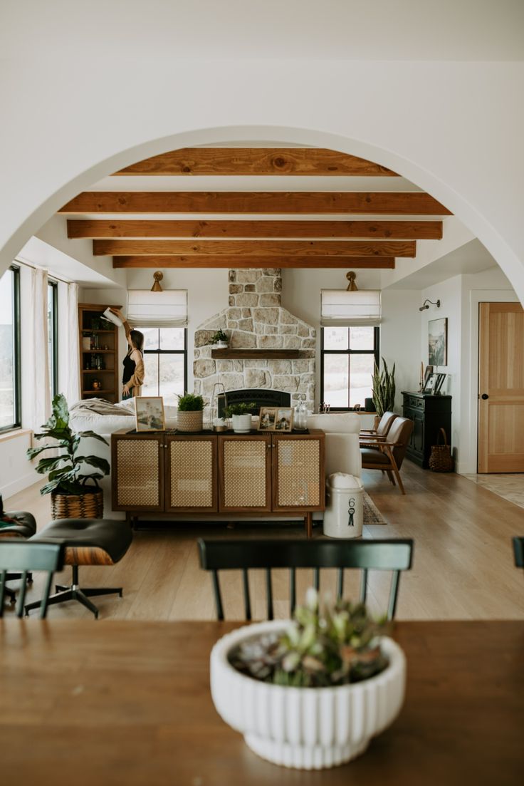 a living room filled with furniture and a fire place next to a dining room table