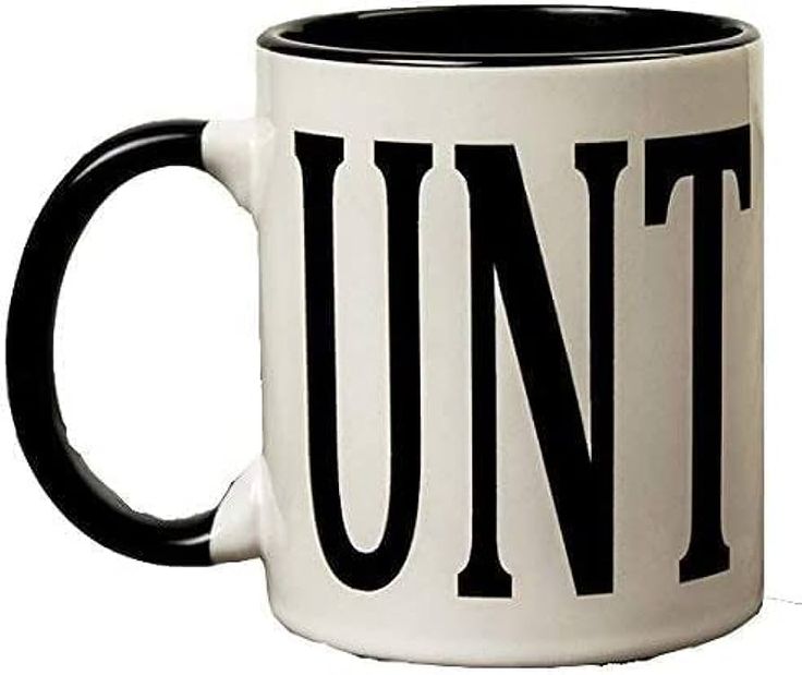 a black and white coffee mug with the word unit printed on it sitting on a wooden table