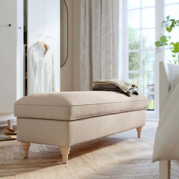 a grey ottoman sitting on top of a hard wood floor