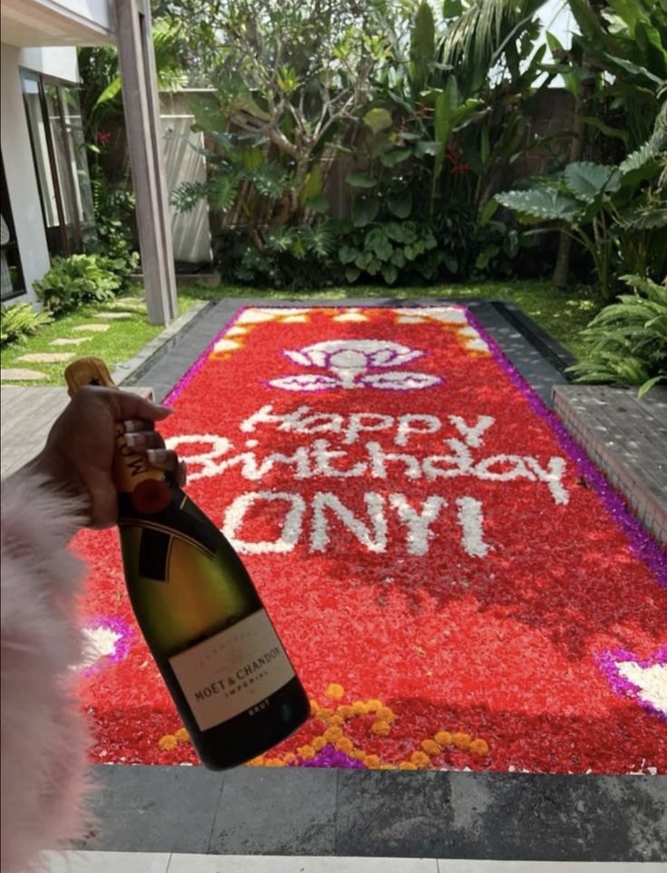 a bottle of wine sitting on top of a red carpet covered in confetti