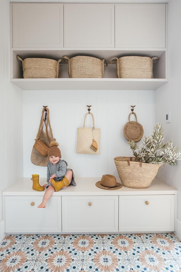 a white shelf with baskets and bags on it