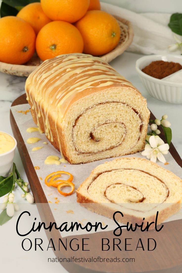 cinnamon swirl orange bread on a cutting board next to some oranges and other fruit