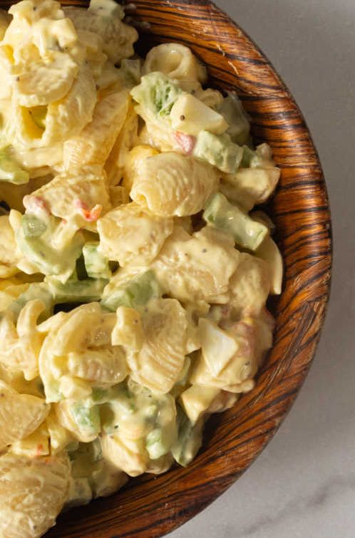 a wooden bowl filled with macaroni salad