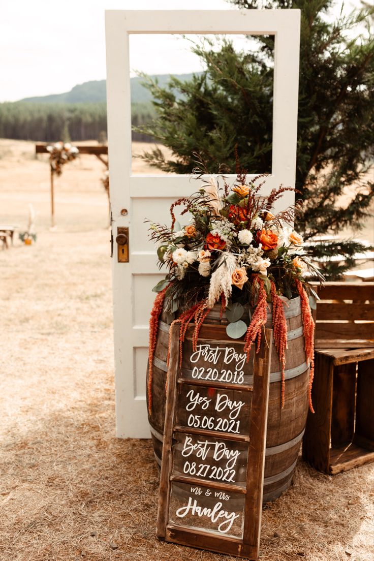 a wooden barrel with a sign and flowers on it