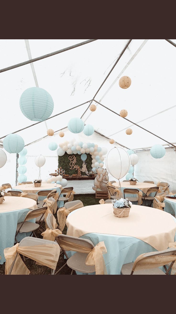 tables and chairs are set up in a tent for a baby's first birthday party