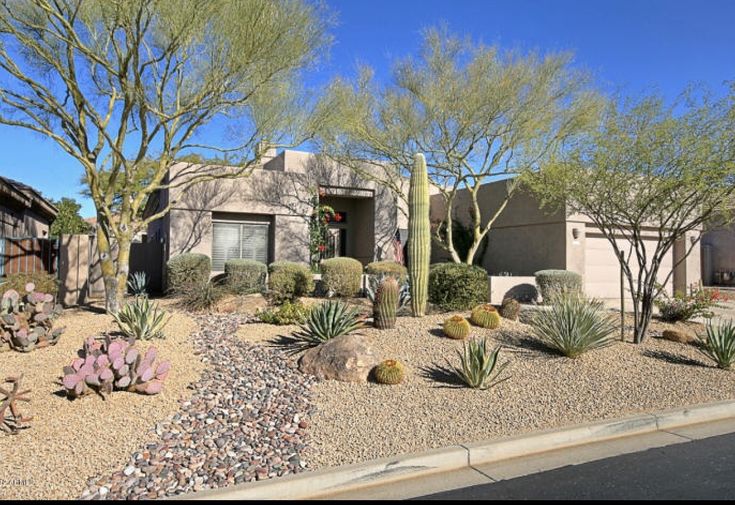 a home with cactus and cacti in the front yard