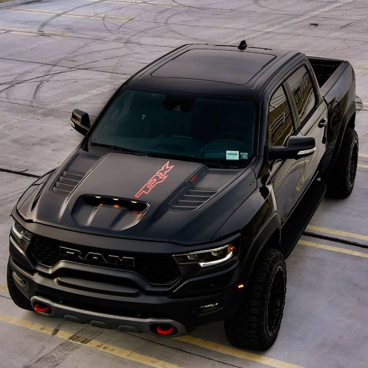 a black truck parked on top of an airport tarmac