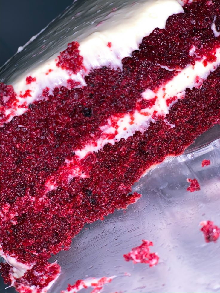 a slice of red velvet cake with white frosting