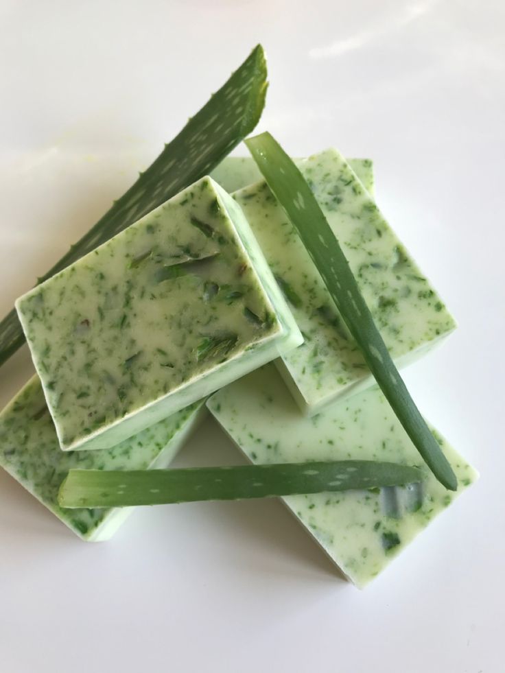 four pieces of soap sitting on top of each other next to an asparagus