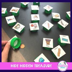 a table with lots of green dices and cards on it that say hide hidden treasures