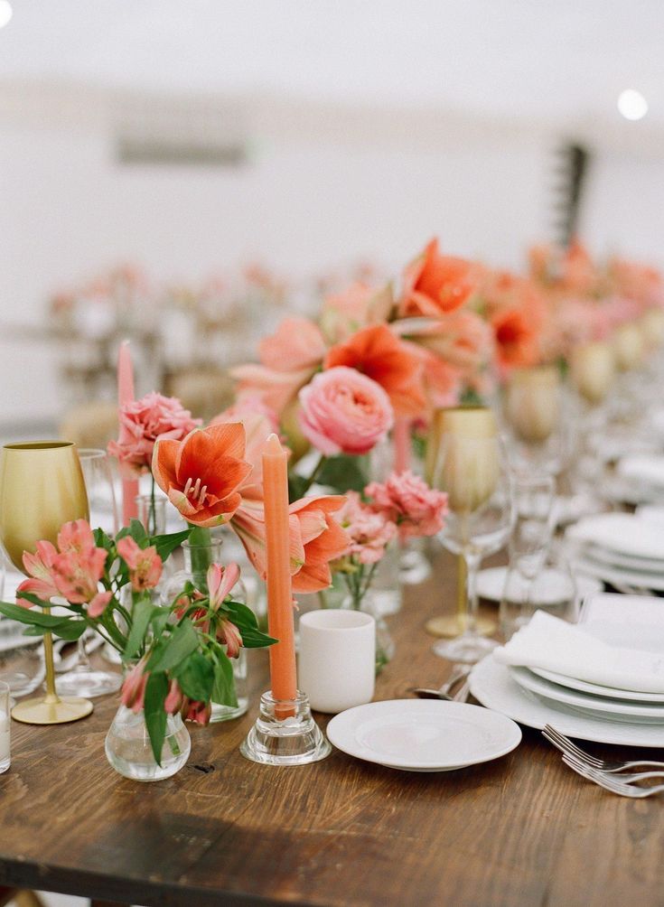 the table is set with candles, plates and flowers