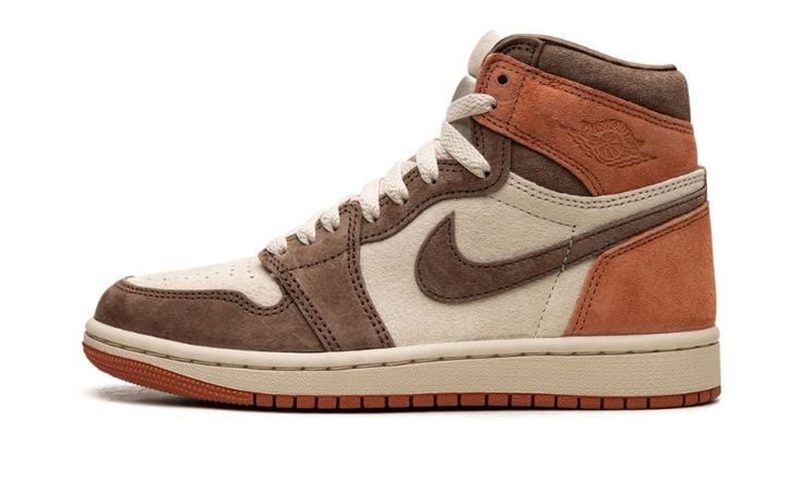 The Women’s Air Jordan 1 High OG “Dusted Clay” is a women’s-exclusive colorway of Michael Jordan’s first signature shoe with an earth tone design.  The upper is complete with a cream suede base with a combination of Cacao Wow suede overlays on the toe, forefoot, eyelets, and Swoosh.  Dusted Clay suede overlays can be found on the collar and heel.  A debossed “Wings” logo appears on the collar, while “Nike Air” branding is seen on the tongue tag.  Underfoot, a cream rubber midsole and a Dusted Cl Clay Shoes, Wmns Air Jordan 1, Jordan 1 High Og, Wings Logo, Air Jordan 1 Retro High Og, Air Jordan 1 High, Jordan 1 High, Air Jordan 1 Retro, Jordan 1 Retro High