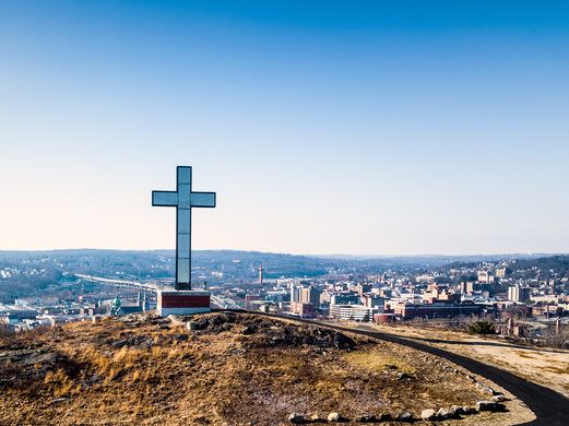 a cross on top of a hill overlooking a city