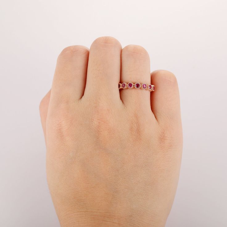 a woman's hand with a pink diamond ring on her left wrist and the other hand holding it up