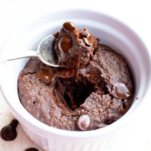 chocolate pudding in a white bowl with spoon