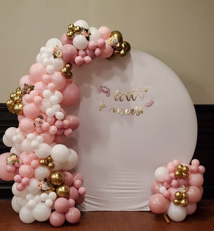 the balloon arch is decorated with pink, white and gold balloons