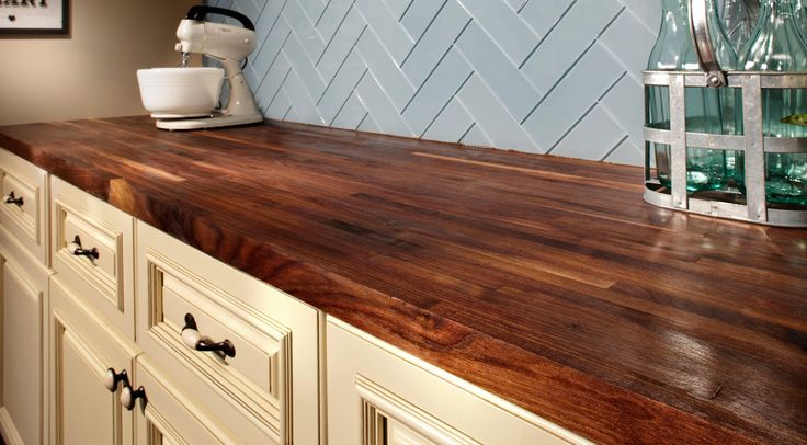 a wooden counter top in a kitchen with white cabinets