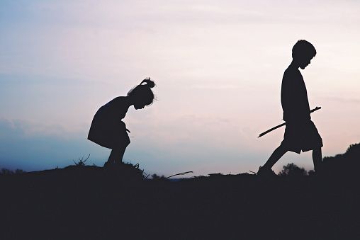 two people are standing in the grass with swords