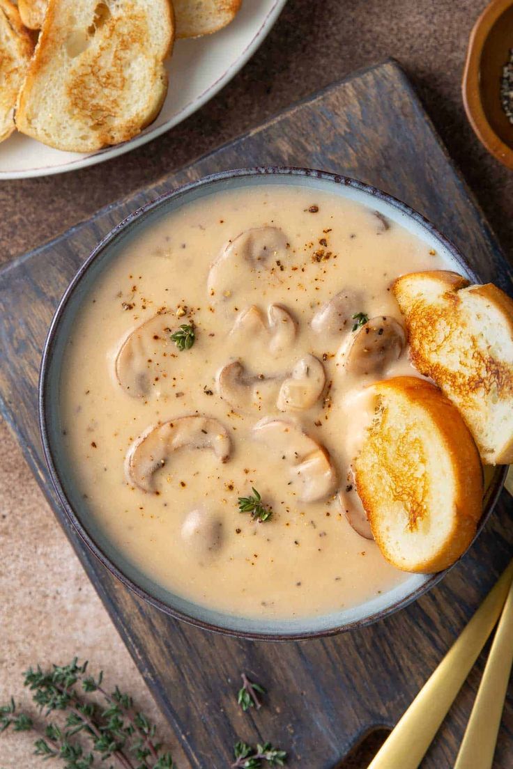 a bowl of soup with bread on the side