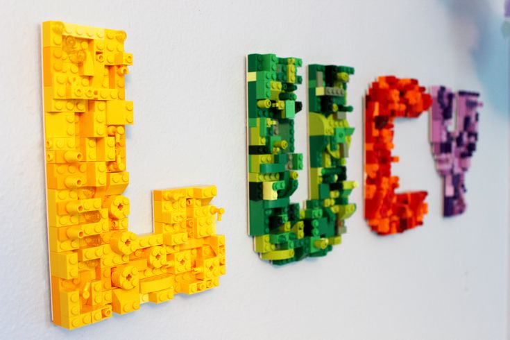 the word lego spelled out in lego letters on a wall next to other colorful toys