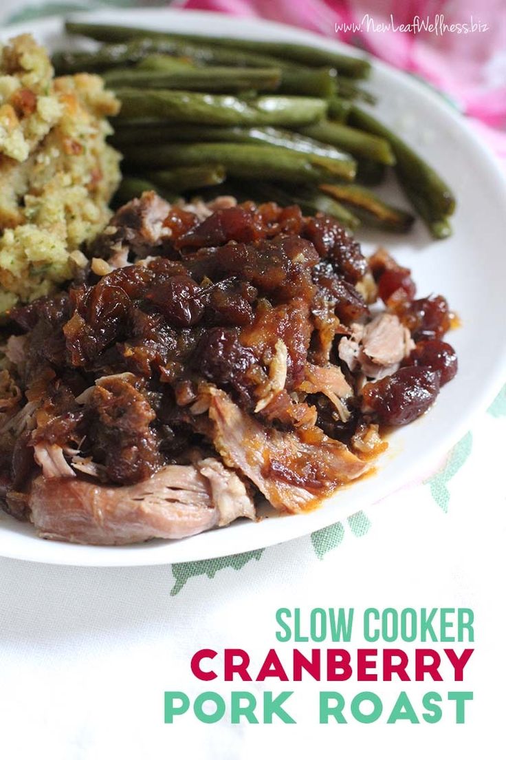 slow cooker cranberry pork roast on a white plate with green beans and mashed potatoes