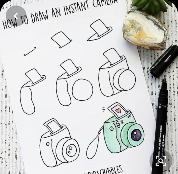 the instructions for how to draw an instant camera on paper next to a rock and pen