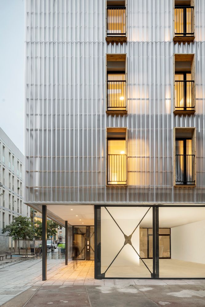 an apartment building with large windows and glass doors