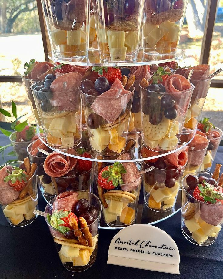 there are many desserts in cups on the table and one is filled with fruit