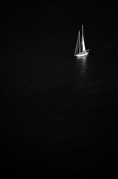 a sailboat floating on the water at night