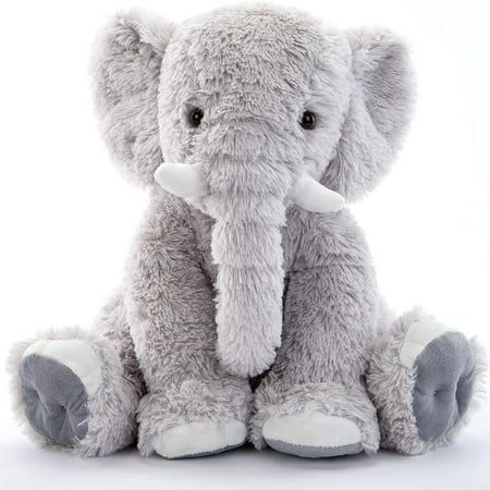 an elephant stuffed animal sitting up against a white background