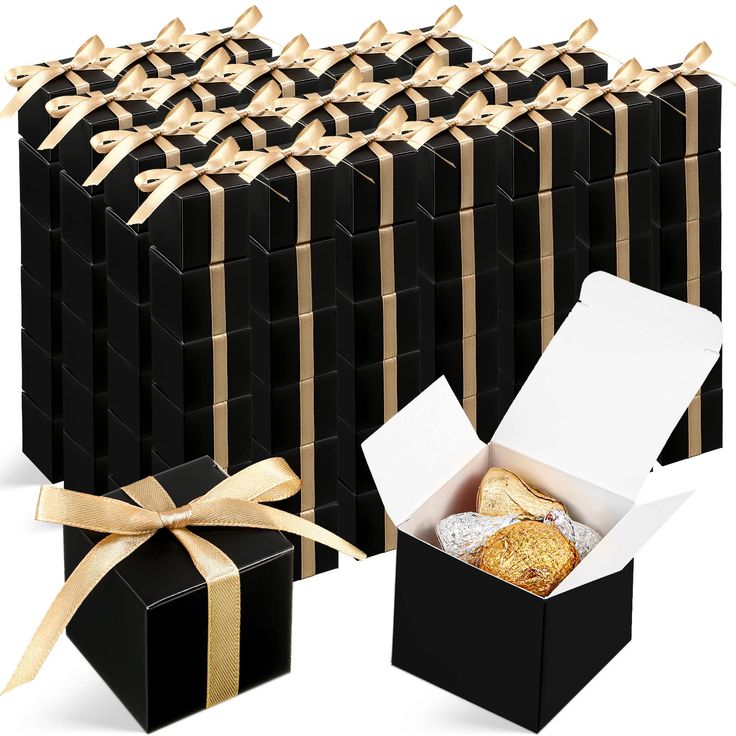 black boxes with gold ribbon and white box containing pastries