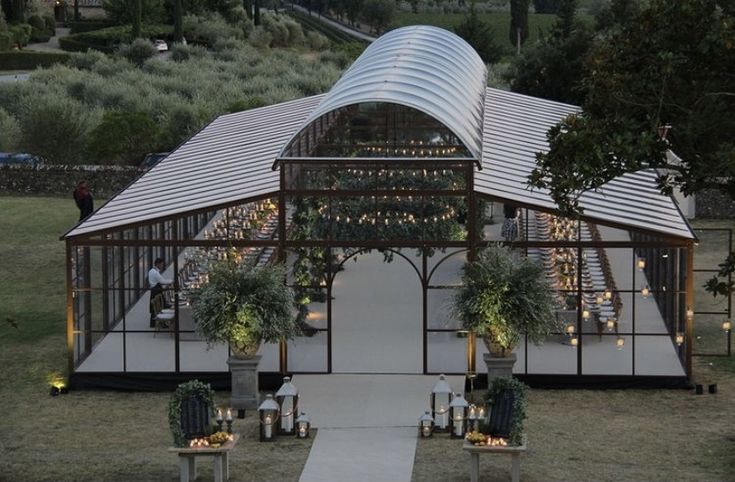 an outdoor wedding venue set up in the middle of a field with greenery and candles