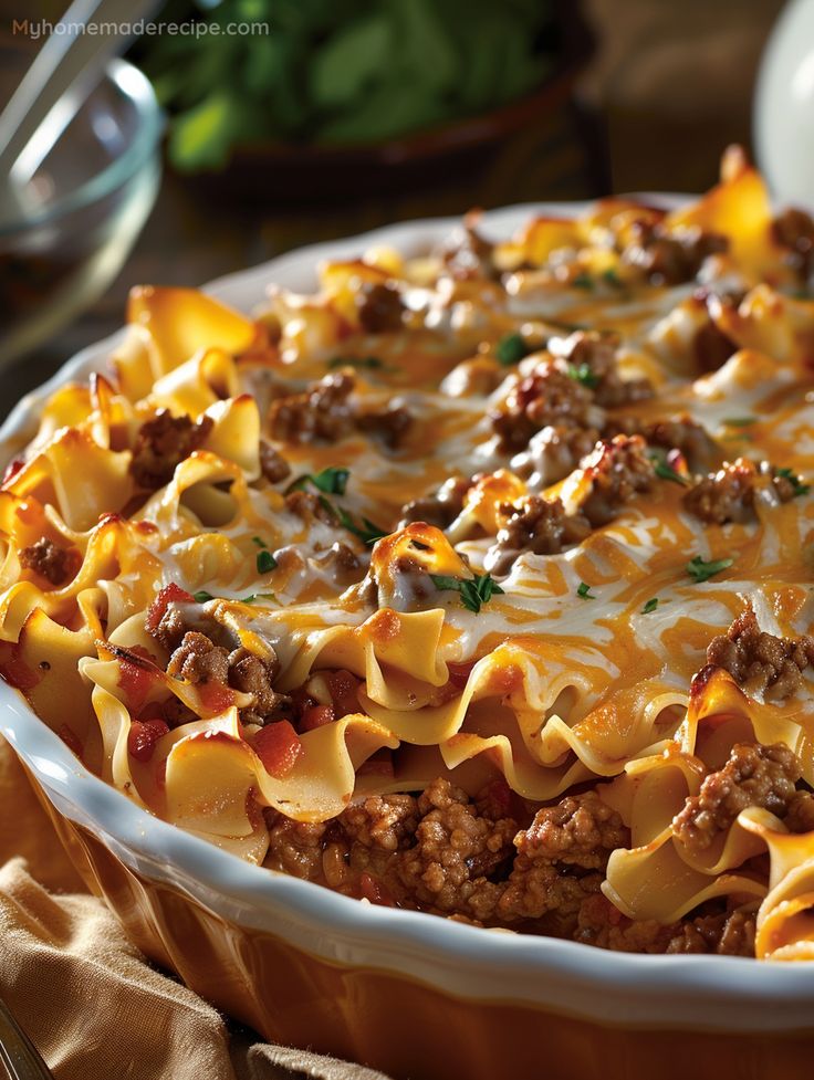 a casserole dish with meat, cheese and sauce in it on a table