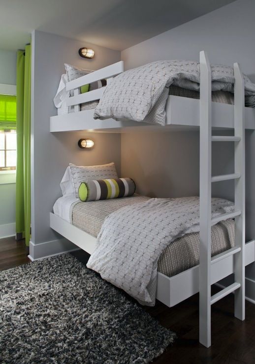 two bunk beds in a small room with green curtains on the windowsill and white bedding