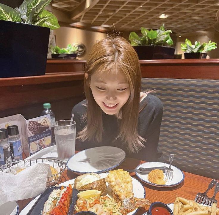 a woman sitting at a table with food in front of her