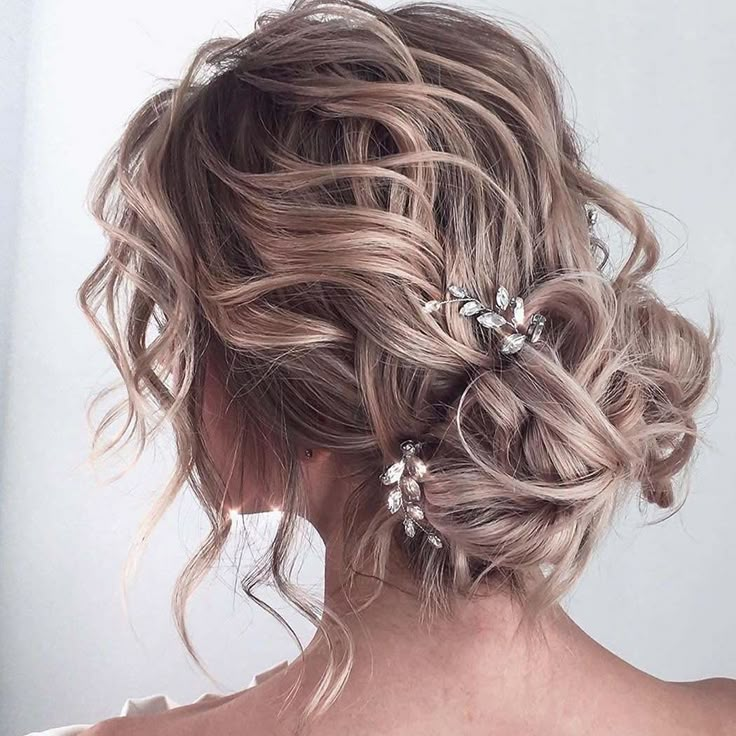 the back of a woman's head with wavy hair and flowers in her hair