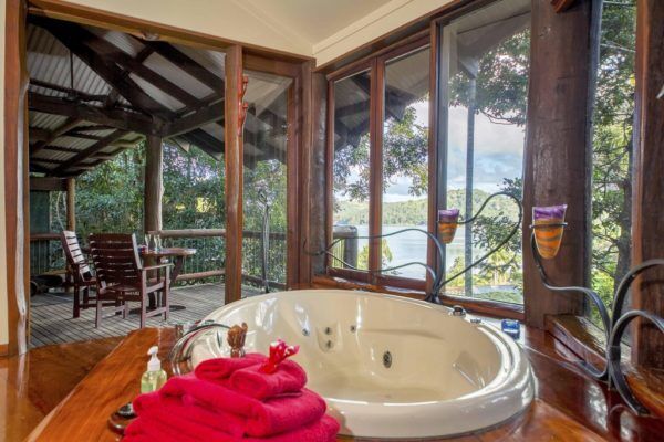 a large jacuzzi tub sitting in the middle of a wooden floored bathroom