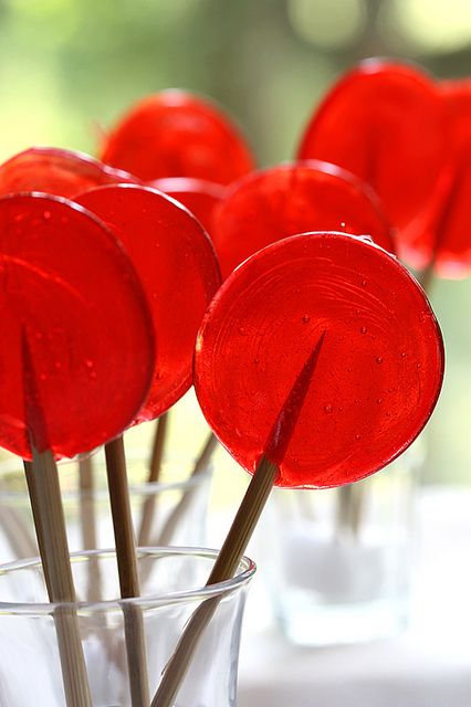 some red lollipop sticks in a glass vase