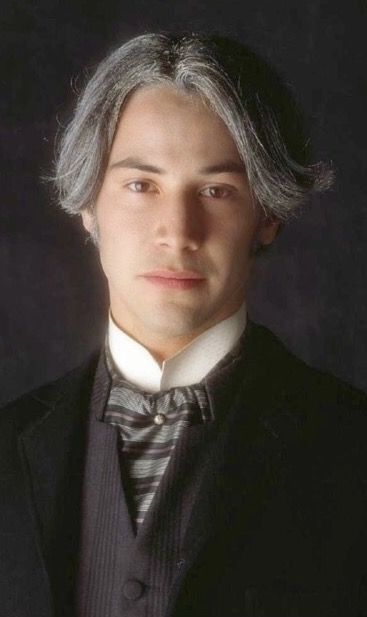 a man with grey hair wearing a suit and bow tie