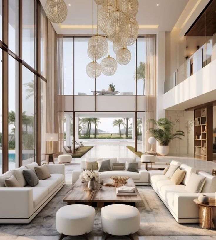 a living room filled with lots of furniture next to tall windows and floor to ceiling windows