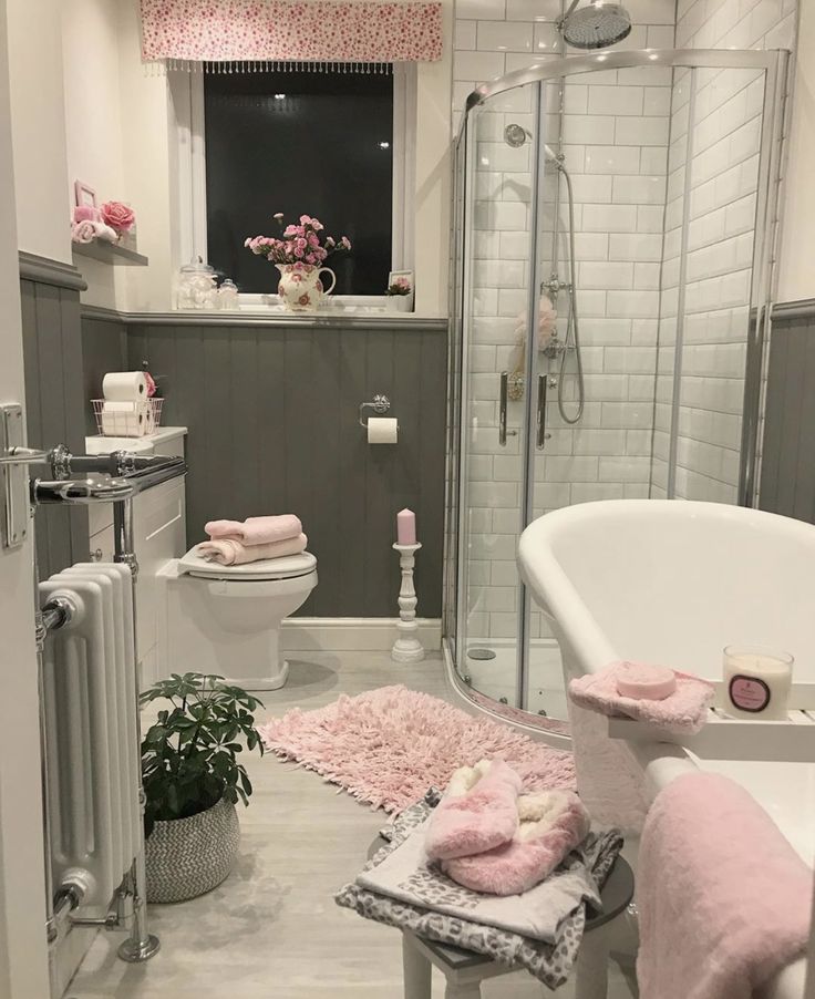 a bathroom with pink and gray decor on the walls, toilet, sink, shower stall and bathtub