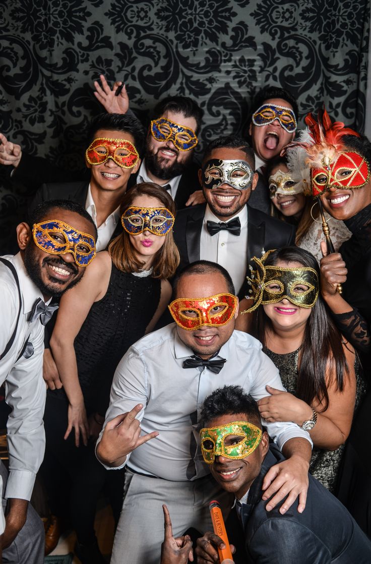 a group of people posing for a photo with masks on their faces and one man in a tuxedo