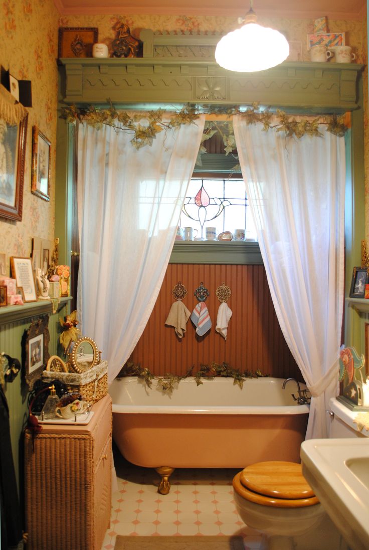 a bath room with a toilet a tub and a window near a sink or toilet