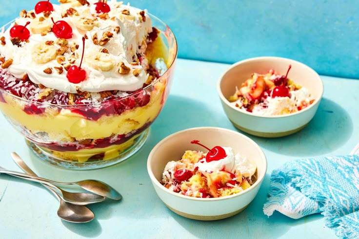 there are three desserts in small bowls with cherries on the top and one has bananas