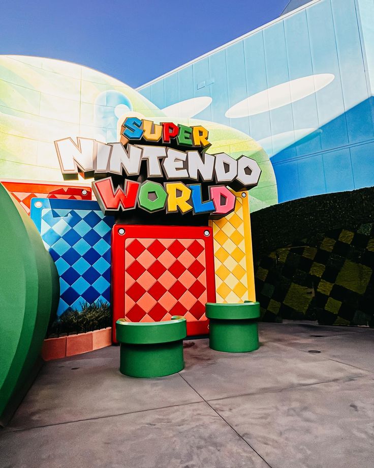 the entrance to an amusement park that is painted in bright colors and has giant letters on it