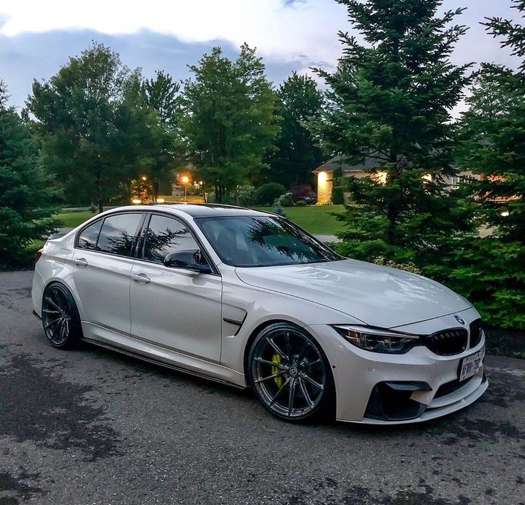 a white car parked in front of some trees